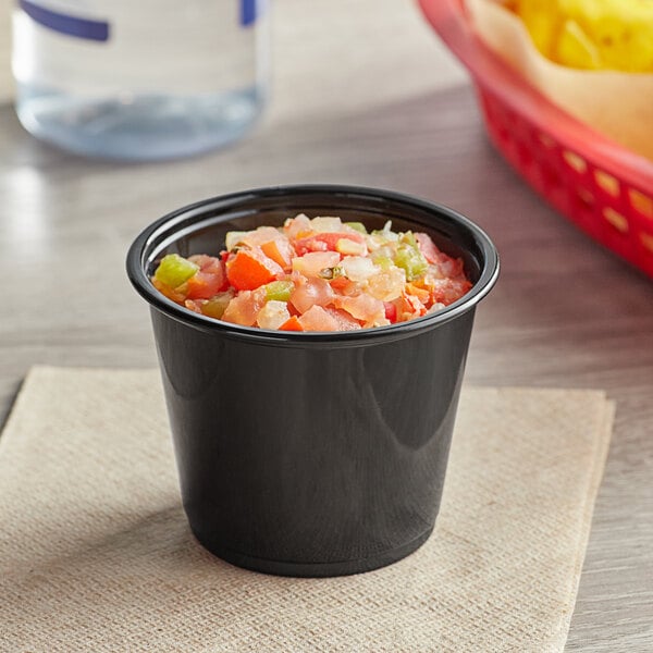 A black plastic Choice portion cup filled with food.