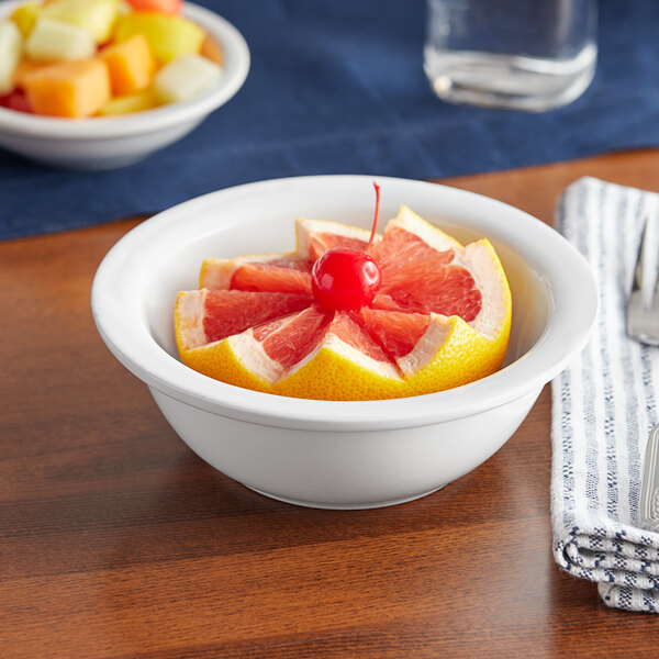A bowl of grapefruit with a cherry on top in an Acopa Bright White stoneware bowl.