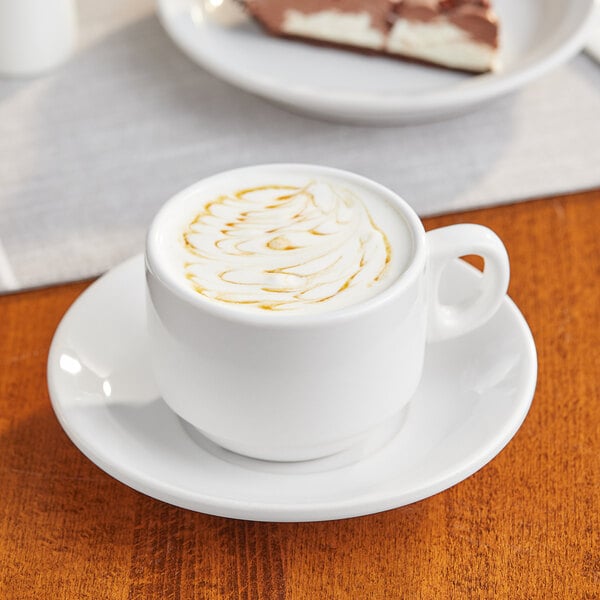 An Acopa white stoneware cup of coffee with a swirl of foam on a white surface