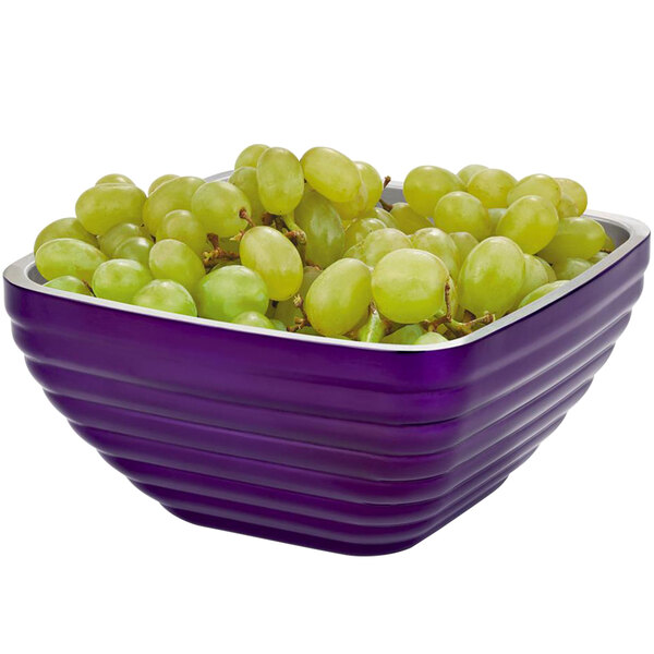 A Vollrath passion purple square metal bowl filled with green grapes.