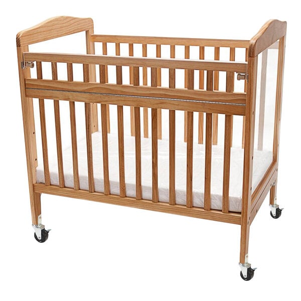A wooden L.A. Baby crib with wheels.