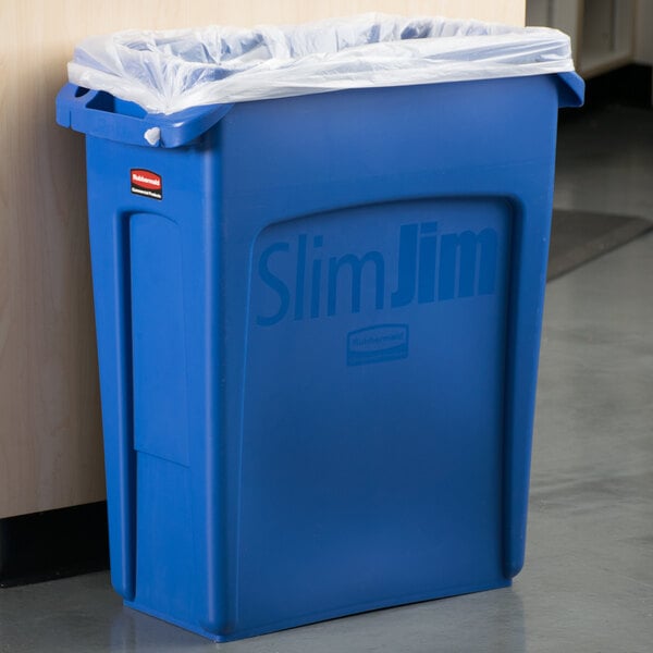 A blue Rubbermaid Slim Jim trash can with a clear plastic bag over it.