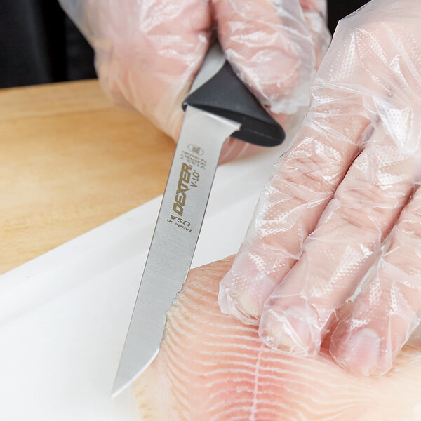 A person in plastic gloves using a Dexter-Russell V-Lo fillet knife to cut fish.
