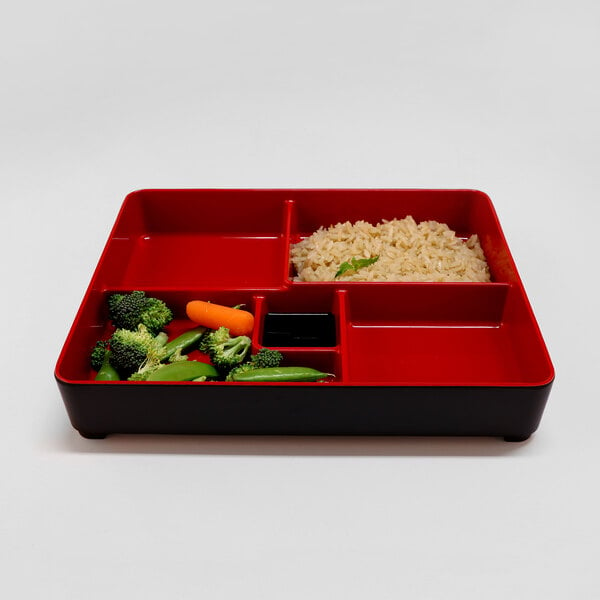 A red and black Bento box tray with rice and vegetables.