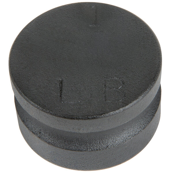 A round black metal cap with the letters "1 lb." on it.