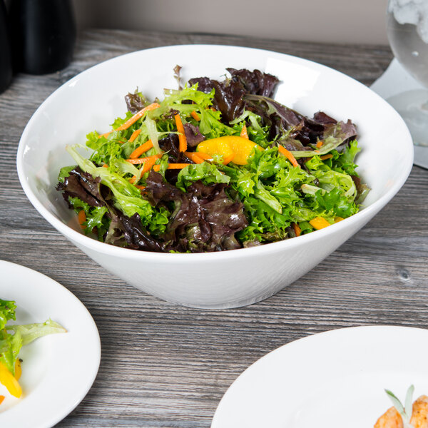 A white Libbey Slenda Perpetua bowl filled with salad with lettuce and orange slices.