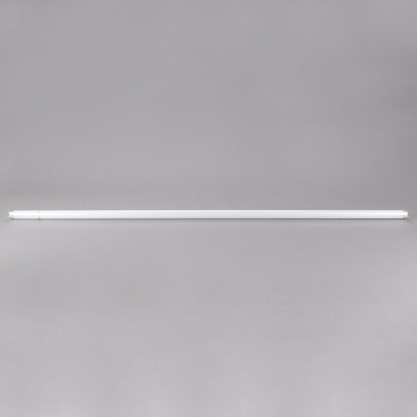 A Satco Shatterproof Cool White fluorescent light bulb on a gray surface.