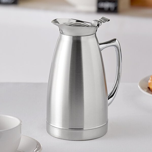 A silver stainless steel thermal coffee server on a table.