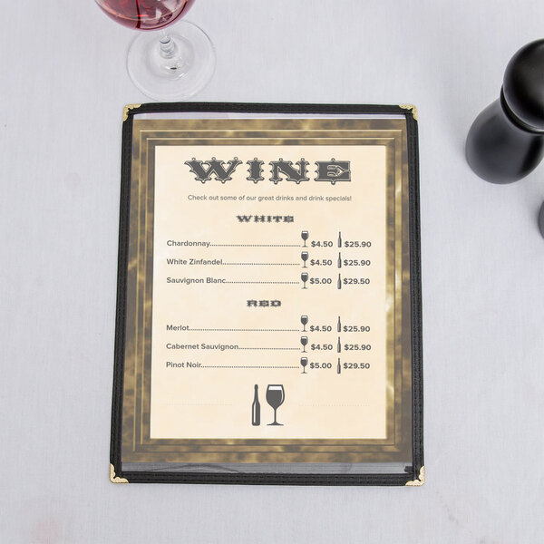A brown menu with a marble border on a table with wine glasses and a bottle of wine.