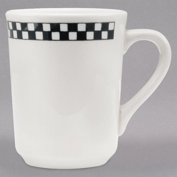 A white mug with black and white checkered trim.