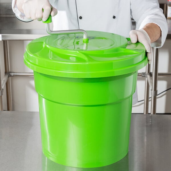 A person holding a green Choice Prep salad spinner bucket.