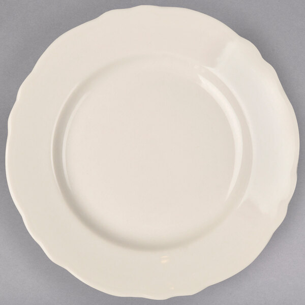 A close-up of a Homer Laughlin ivory scalloped edge bread and butter plate on a white background.