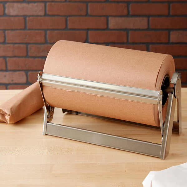 A Bulman stainless steel paper cutter with a roll of brown paper on a wooden surface.