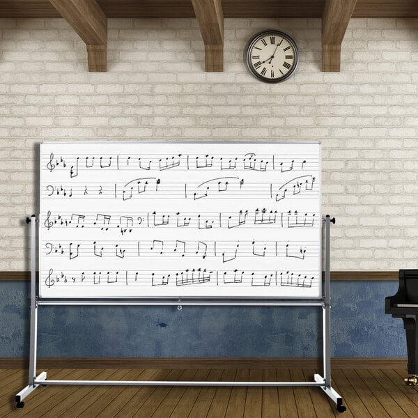 A Luxor double-sided magnetic music whiteboard with musical notes on it in front of a piano.