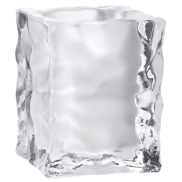 A clear glass ice cube candle holder with a rough surface.