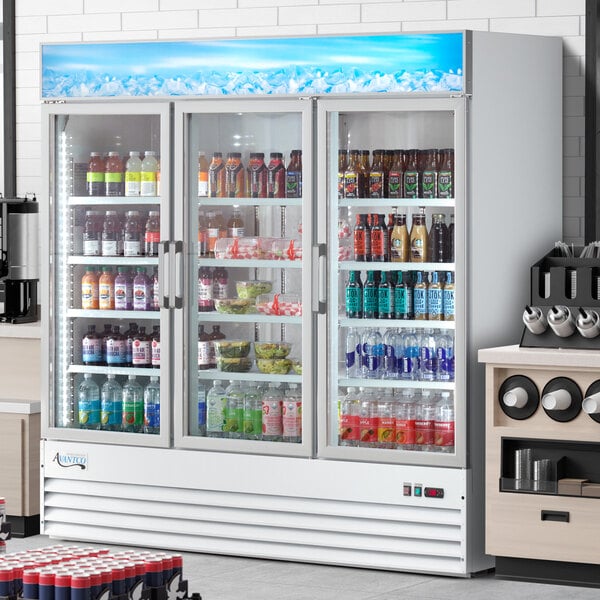 An Avantco white swing glass door merchandiser refrigerator with drinks and beverages on shelves.