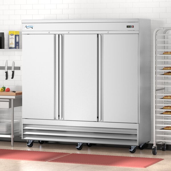 An Avantco stainless steel reach-in freezer with solid doors in a kitchen.