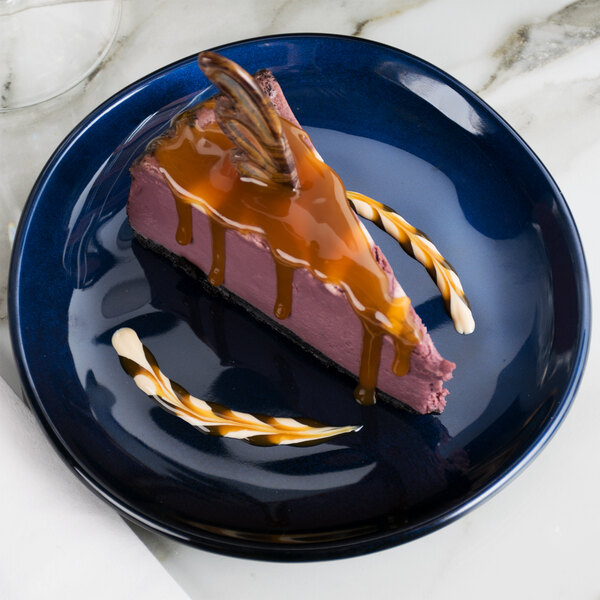 A piece of chocolate cake with caramel sauce on a blue plate.