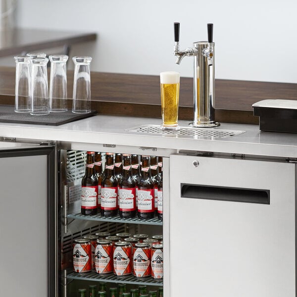 An Avantco stainless steel beer dispenser with two taps on a counter.