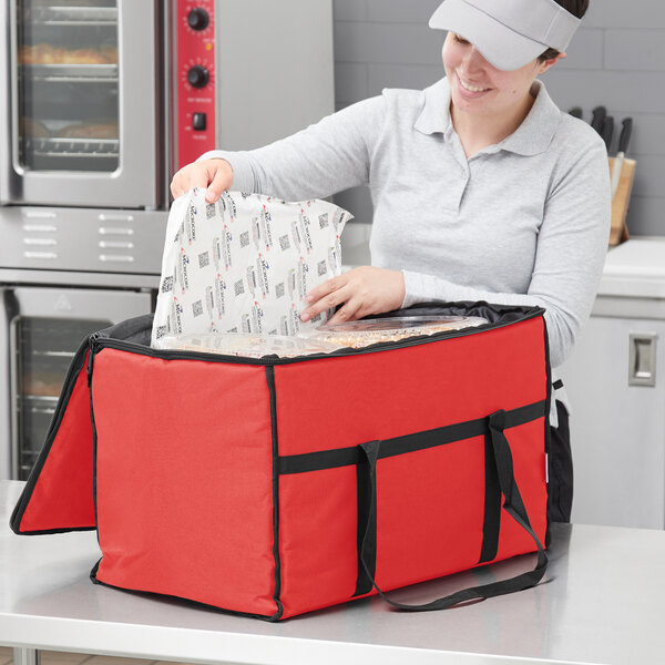 A woman opening a red Choice insulated food delivery bag.