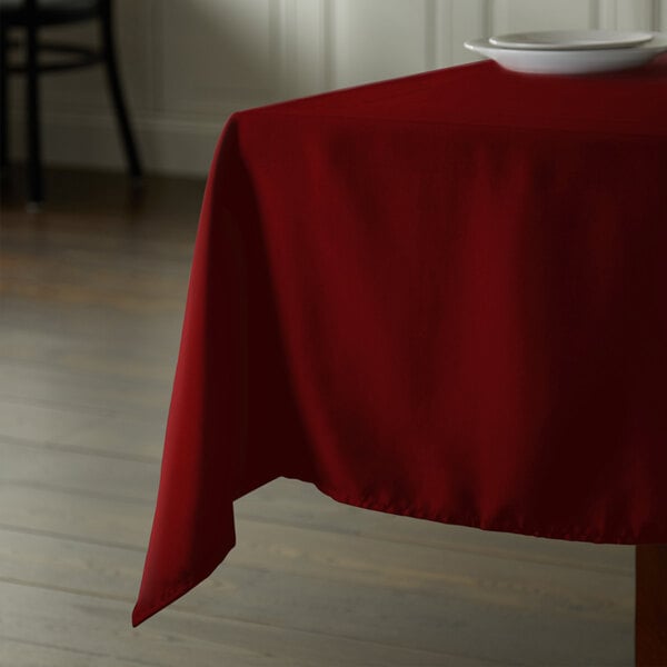 A burgundy Intedge square table cloth on a table.
