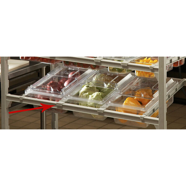 A shelf with Cambro divider bars holding plastic containers of vegetables.