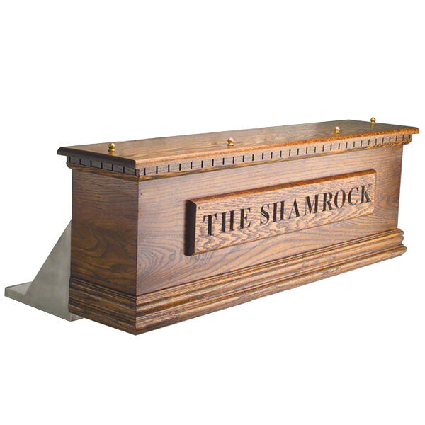 A dark oak wooden Irish coffin box with six taps and the word "Irish" engraved on it.