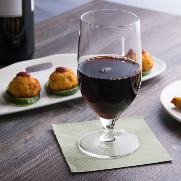 A Reserve by Libbey Neo wine goblet filled with red wine on a table with appetizers.