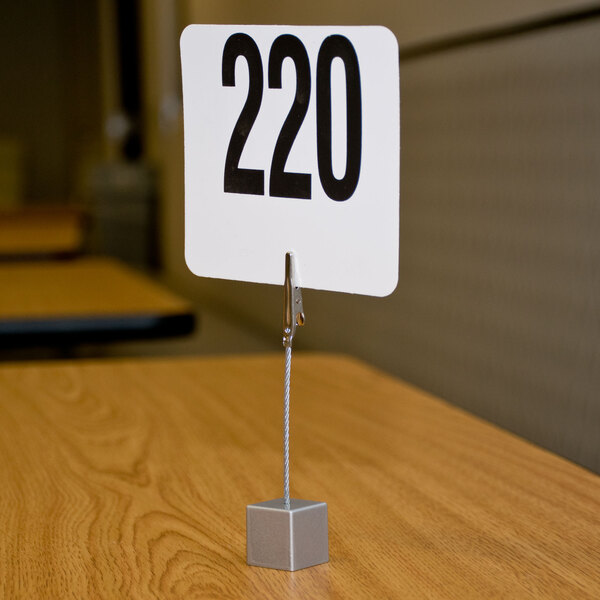 An American Metalcraft square aluminum alligator clip table card holder with a number sign in it.