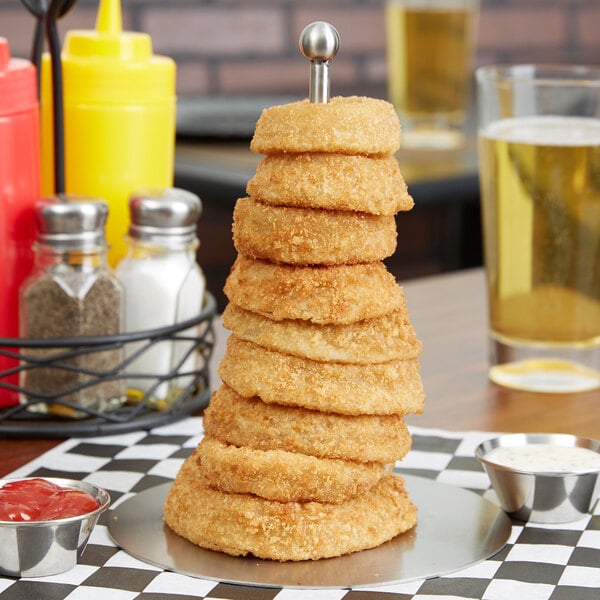 A Clipper Mill stainless steel onion ring tower filled with fried onion rings on a table.