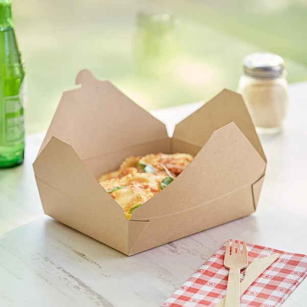 Kraft microwavable paper take-out container with food on a table.