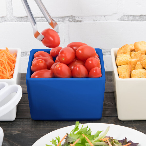 A Tablecraft cobalt blue square bowl filled with tomatoes.
