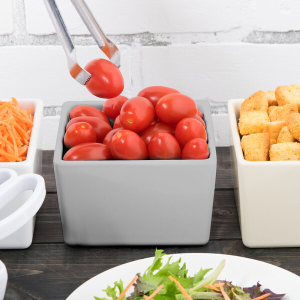 A Tablecraft gray straight sided bowl filled with cherry tomatoes and croutons on a table.
