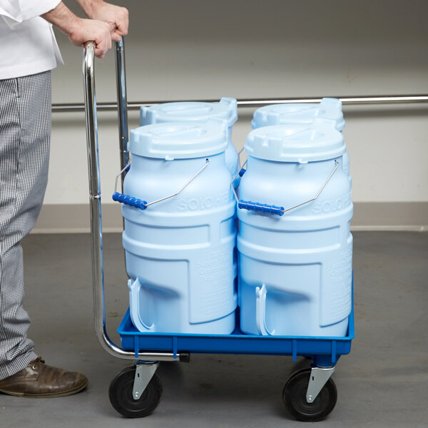 A man pushing a cart with five blue Vollrath Traex ice totes.