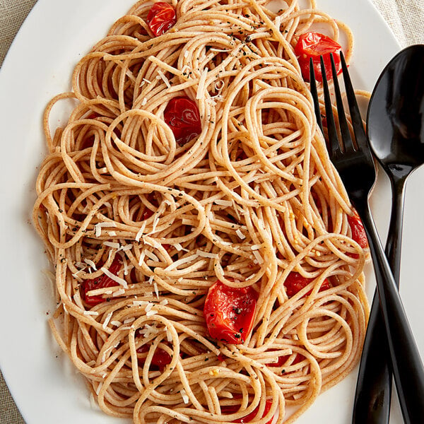 A plate of Regal whole wheat spaghetti with tomatoes and parmesan.