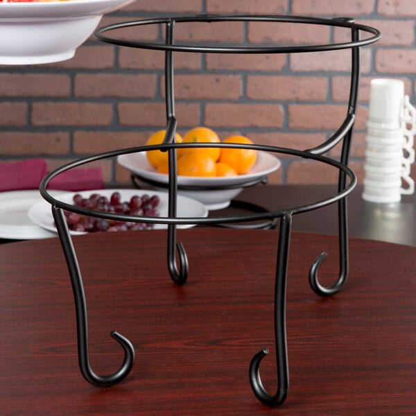 An American Metalcraft Ironworks two-tier metal display stand with fruit in a bowl on top.