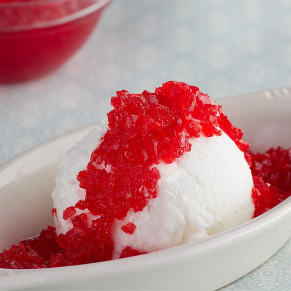A bowl of ice cream topped with crushed red Maraschino cherries.