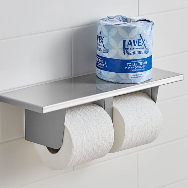 A Lavex toilet paper roll on a metal shelf.
