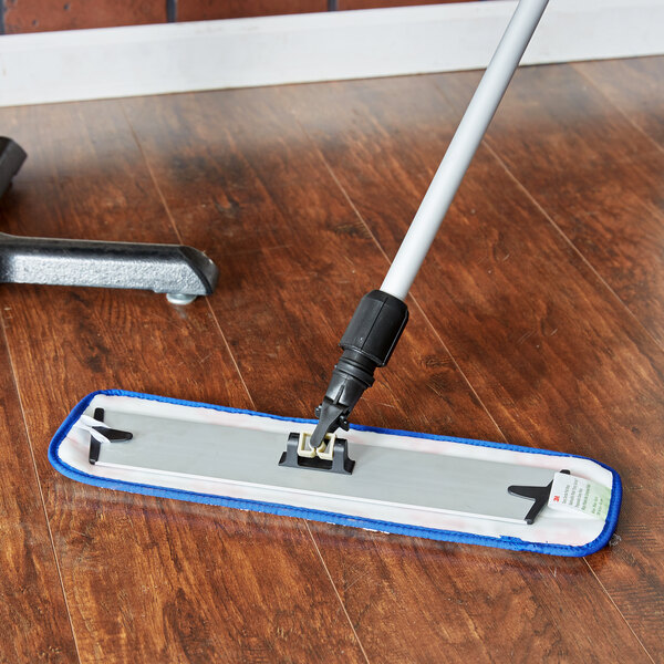 A 3M blue wet mop pad on a wood floor.