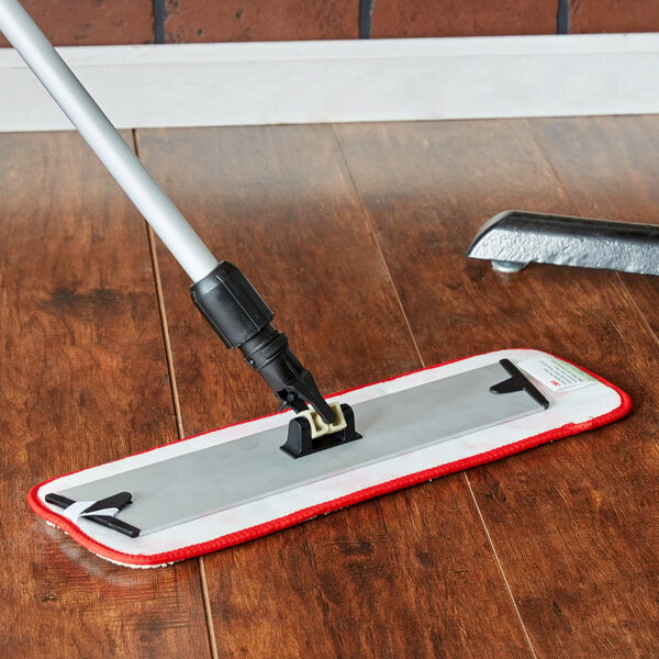 A 3M red and white wet mop pad on a wood floor.