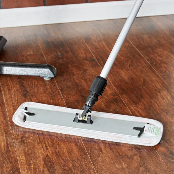 A 3M white wet mop pad on a wood floor.