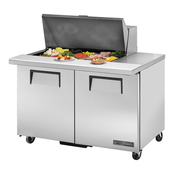 A True TSSU-48-15M-B-HC refrigerated sandwich prep table on a counter with food.