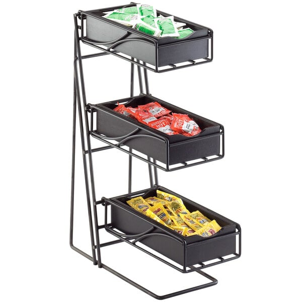 A black metal shelf with three trays of condiments on a counter.