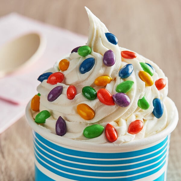 A white cup of ice cream with Chocolate Covered Sunflower Seed Candy Gems on top.