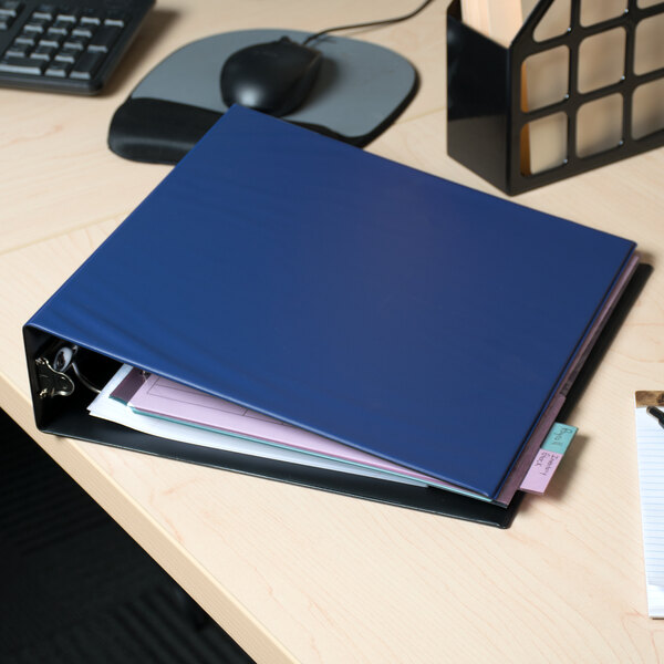 A blue Avery economy binder on a desk with papers inside.
