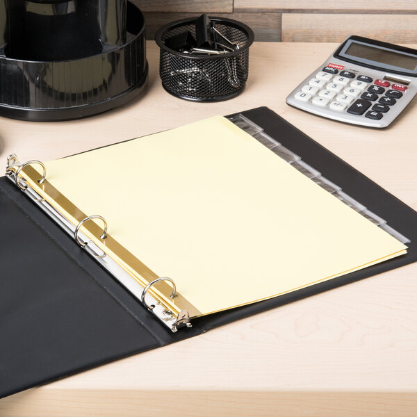 A binder with Avery Big Tab Buff paper dividers inside and a yellow sheet of paper on top.