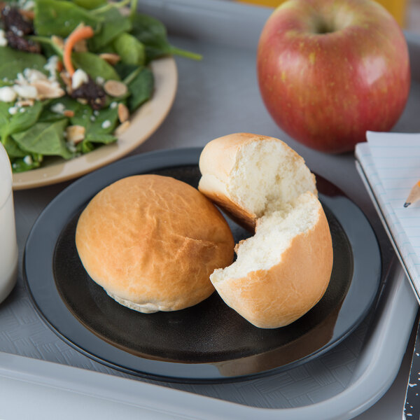 A Carlisle black polycarbonate plate with a sandwich and salad on a lunch tray.