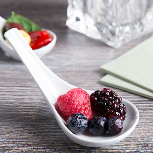 A Tuxton TuxTrendz tasting spoon with berries on it.
