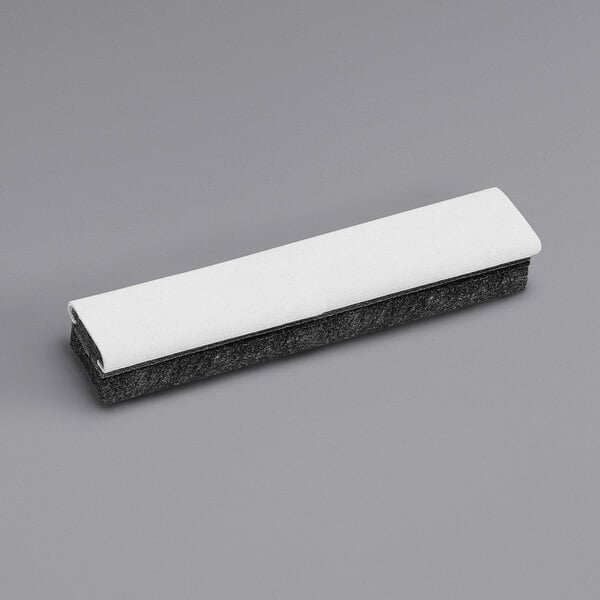 A black and white rectangular felt eraser with a white cover.