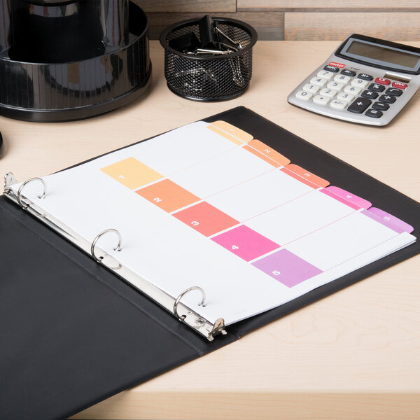 A black binder with Avery Ready Index multi-color tabs on a table.